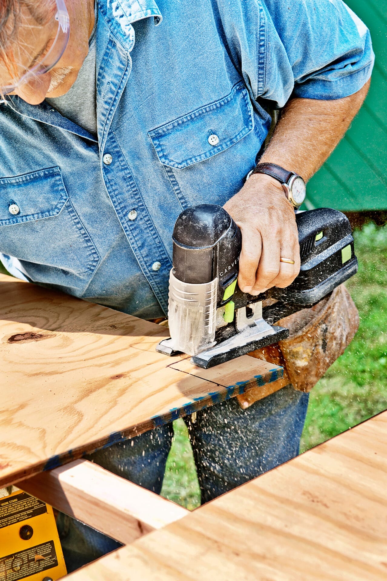 Tom Silva cuts a notch in the plywood for the chicken coop.
