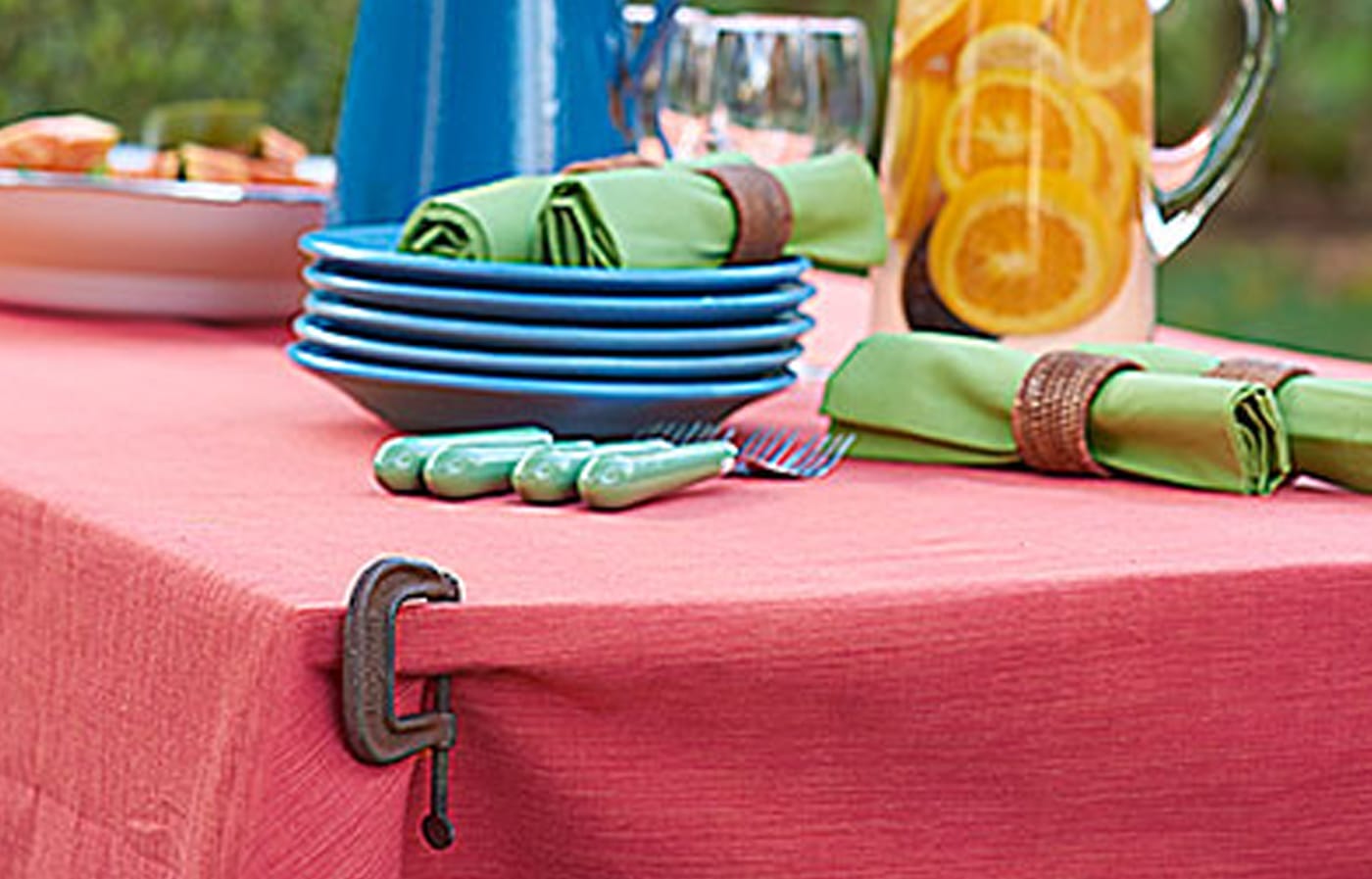 A C-clamp being used to hold a tablecloth onto a table.