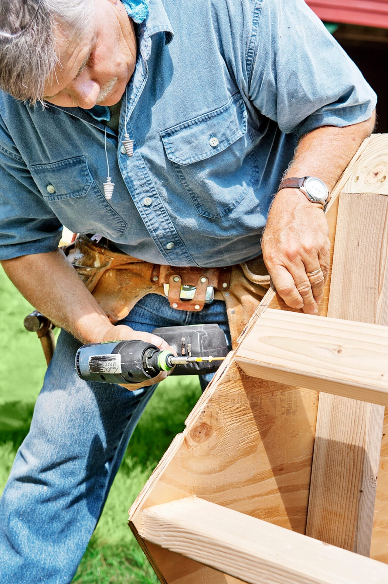 Tom Silva attaches a sidewall to the roof structure of the chicken coop.