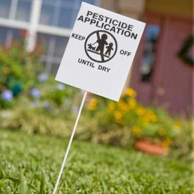 Sign warning of pesticide application in a lawn.