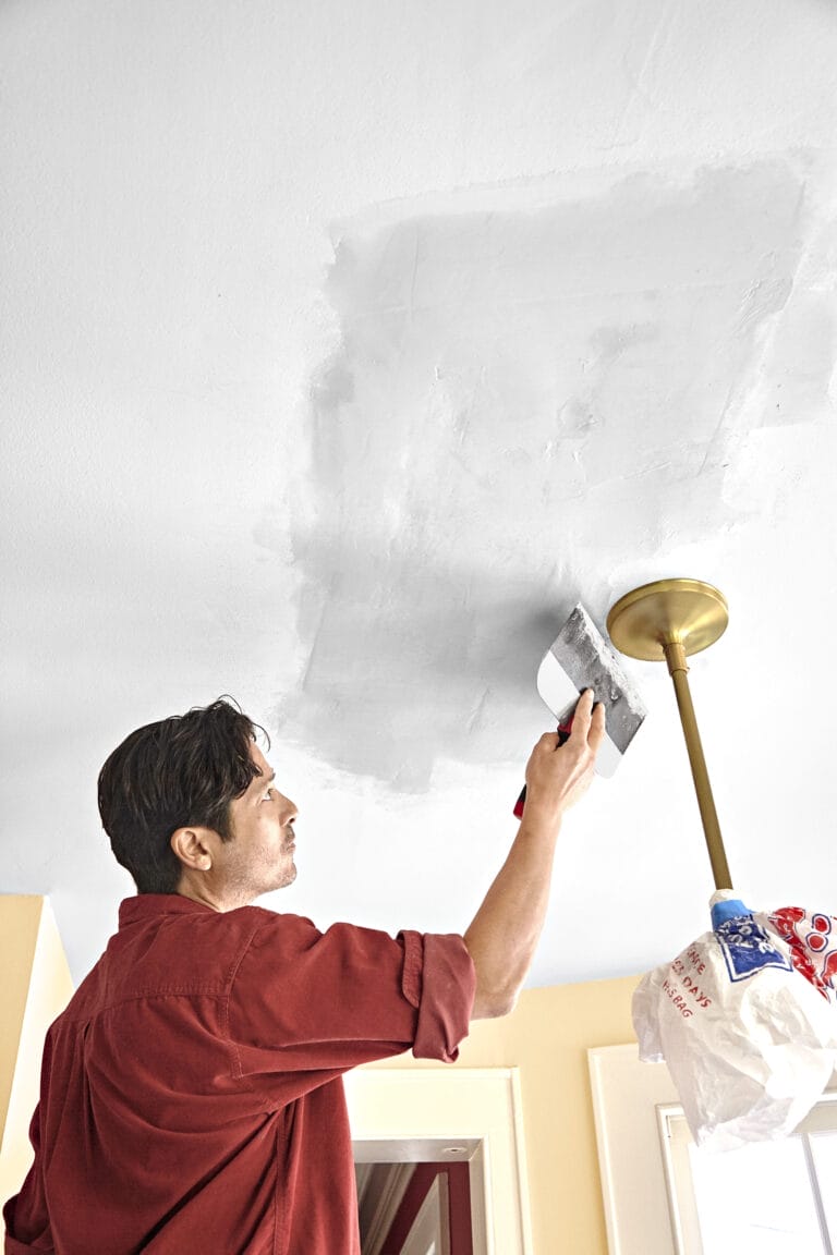 spreading ceiling compound on the damaged area