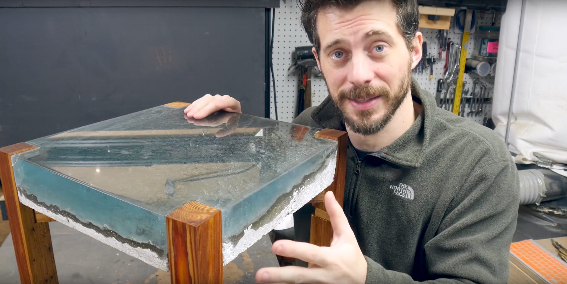 Image of someone demonstrating one of the steps of making an ocean epoxy table, which is to attach the table to the frame