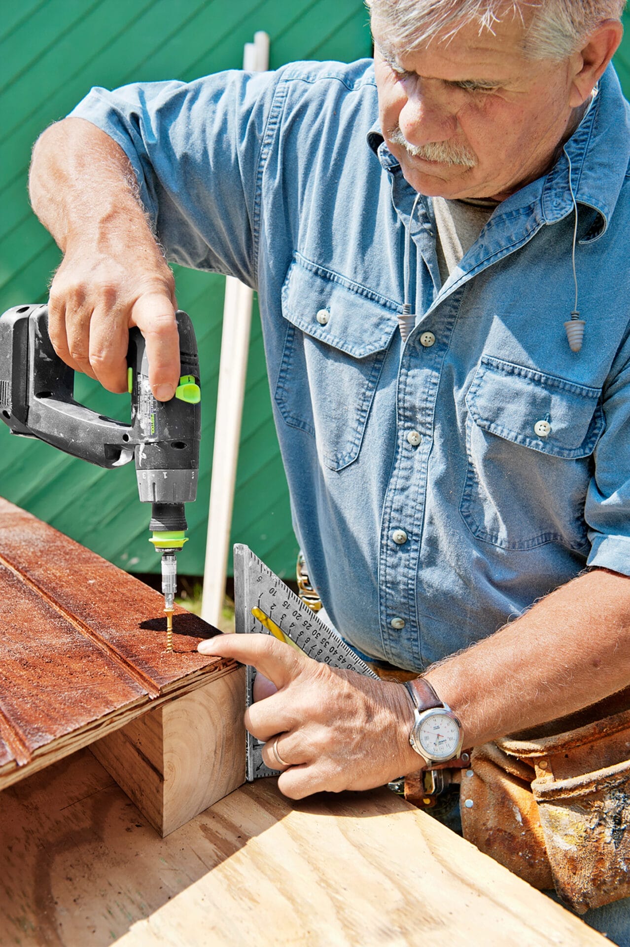 Tom Silva drills together the chicken coop posts and sheathing.
