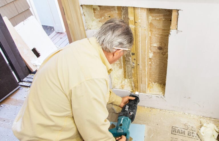 Cutting the drywall for dog door installation