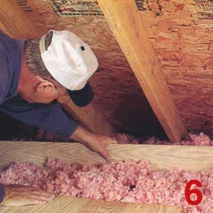 Photo of a contractor ensuring no insulation is blocking vents in the attic to ensure proper attic ventilation