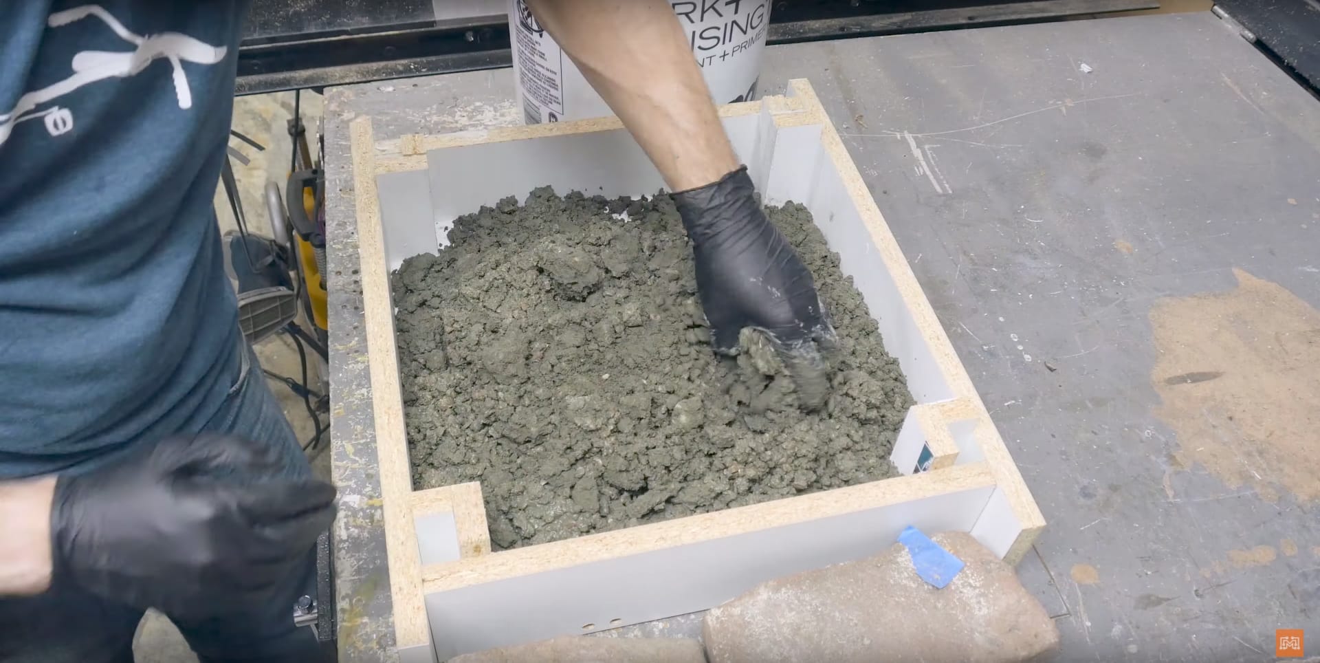 Image of someone demonstrating one of the steps of making an ocean epoxy table, which is to pour concrete into the concrete form