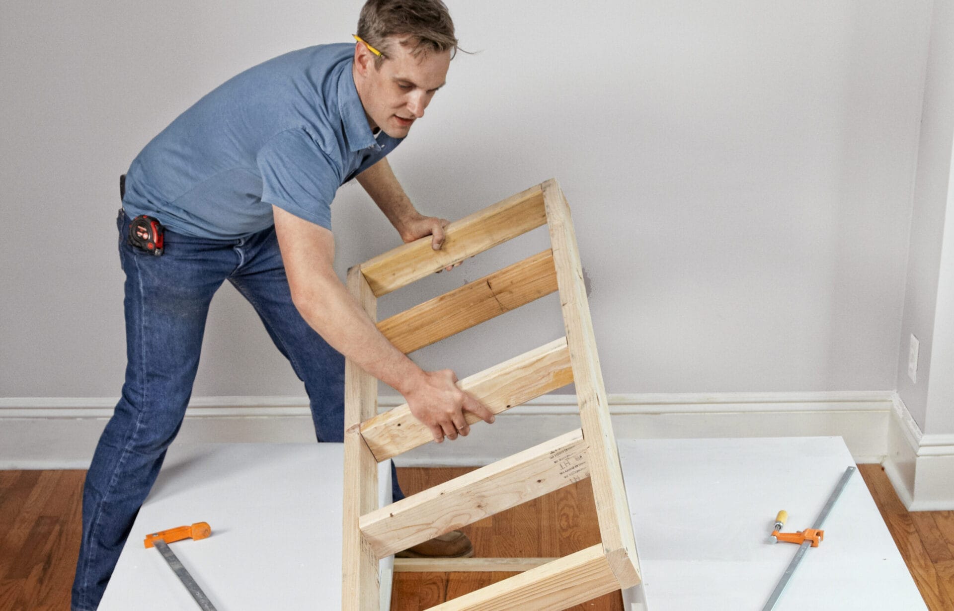 A man installs the support frame of a storage bed.