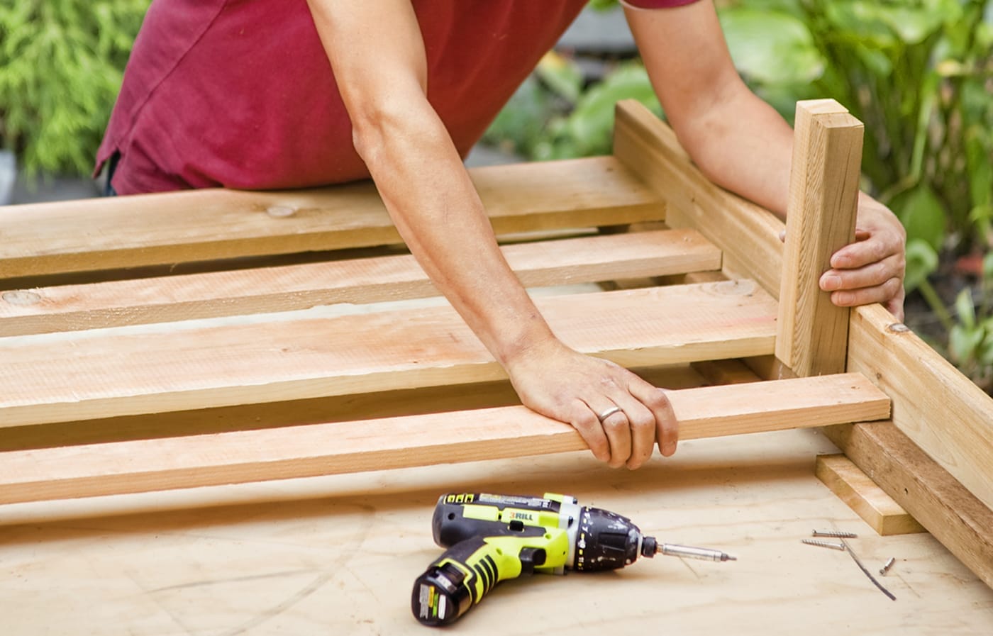 A person installs horizontal slates for the privacy planter.