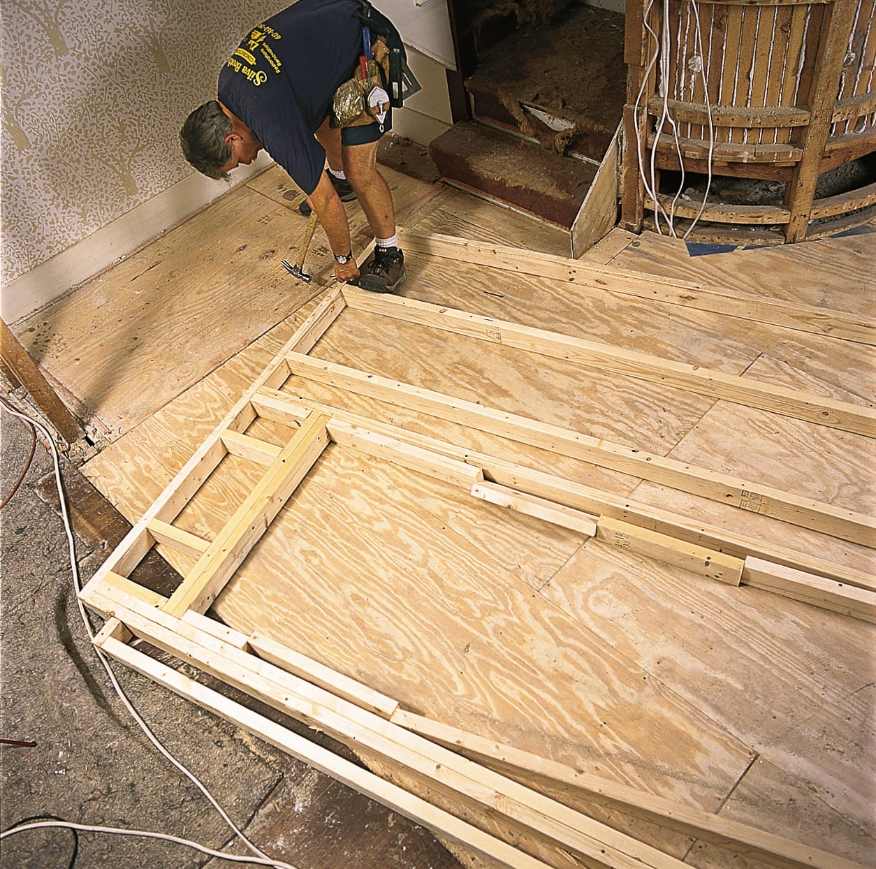 Builder nails together the framing pieces of the partition wall.
