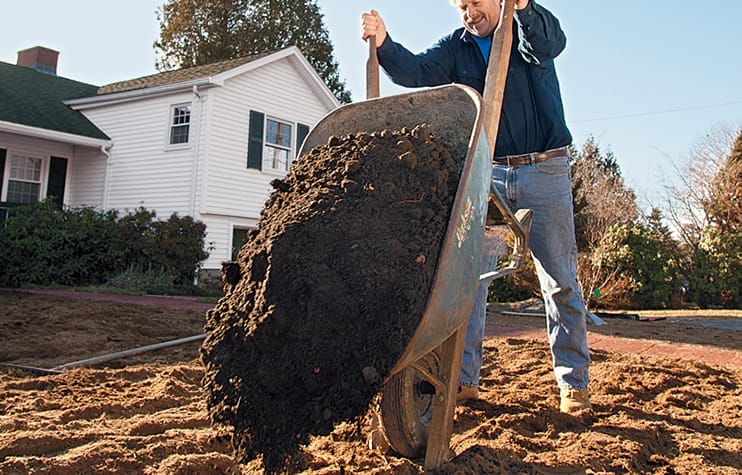 spreading compost onto the lawn