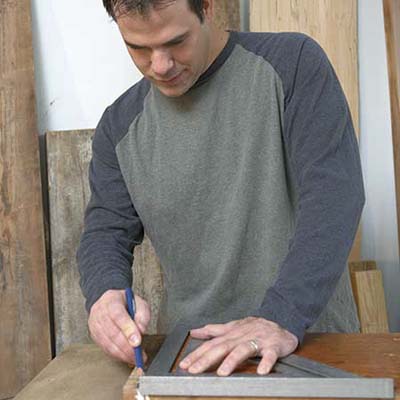 A man marks the stair tread piece to remove the returns.