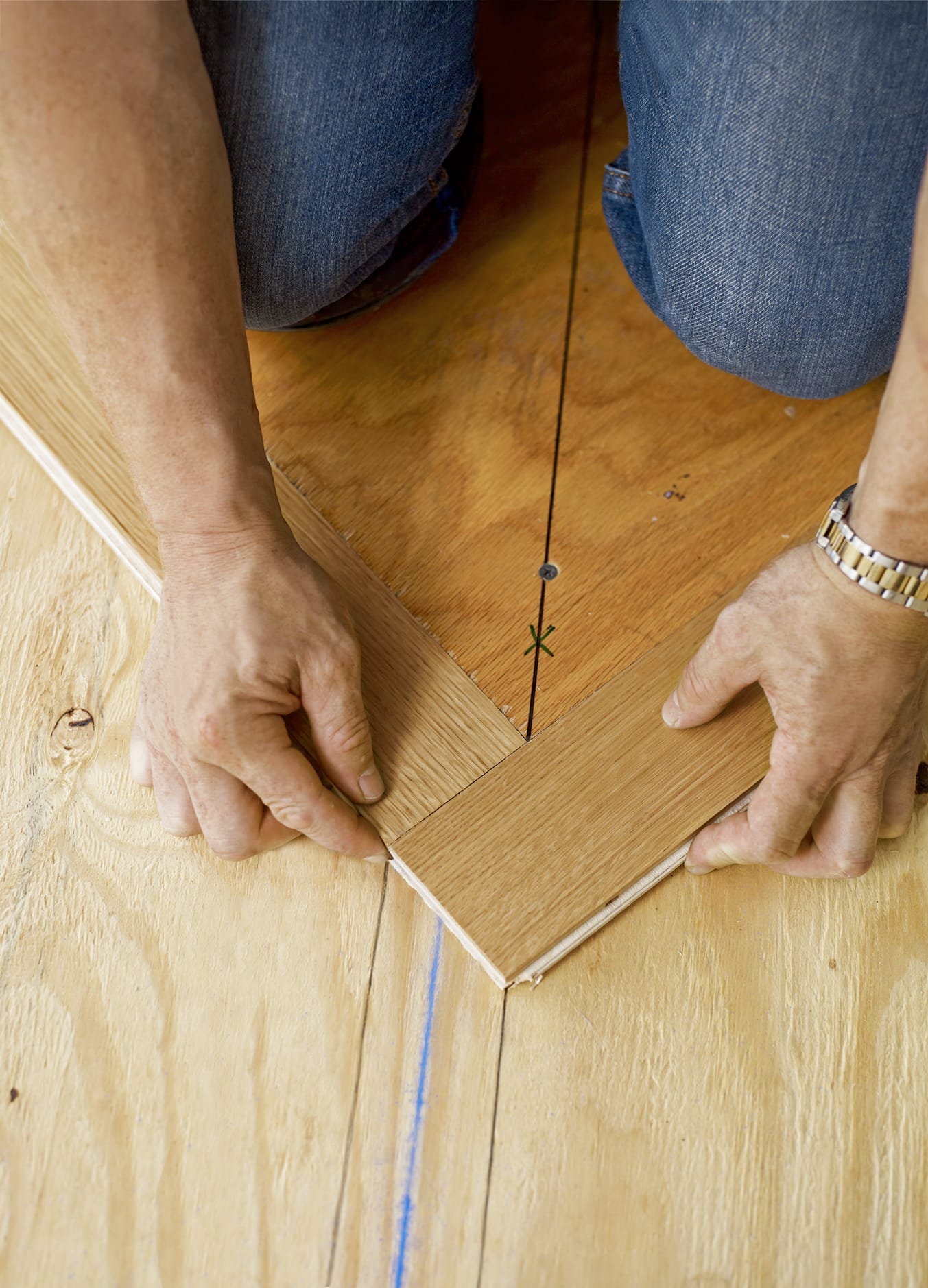 A person places the slats around the nailing blank to establish the herringbone pattern.