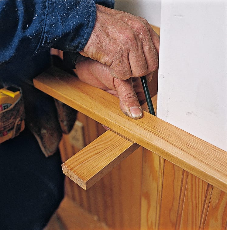 Image of a step of the beadboard wainscoting installation process, which involves marking cap rails to length