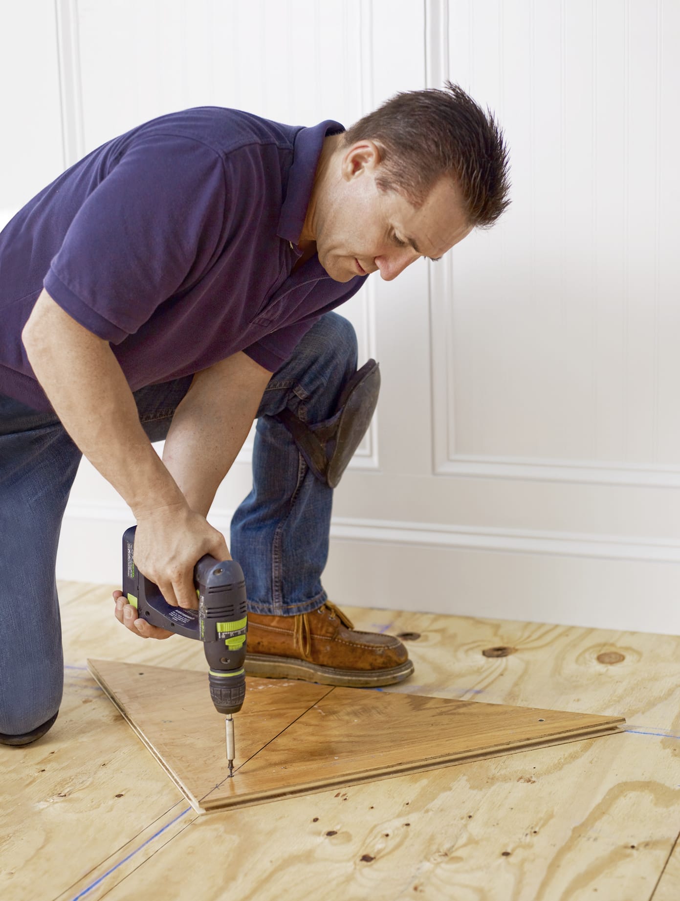 An installer drills the nailing blank into the floorboard so that herringbone flooring can be added.