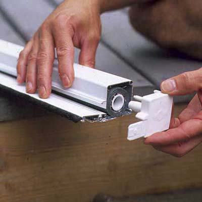 A storage cassette is being installed to a retractable screen door.