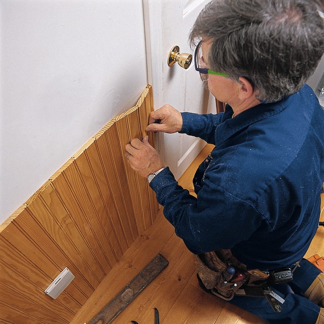 Image of a step of the beadboard wainscoting installation process, which involves fitting the beadboard against the door casing