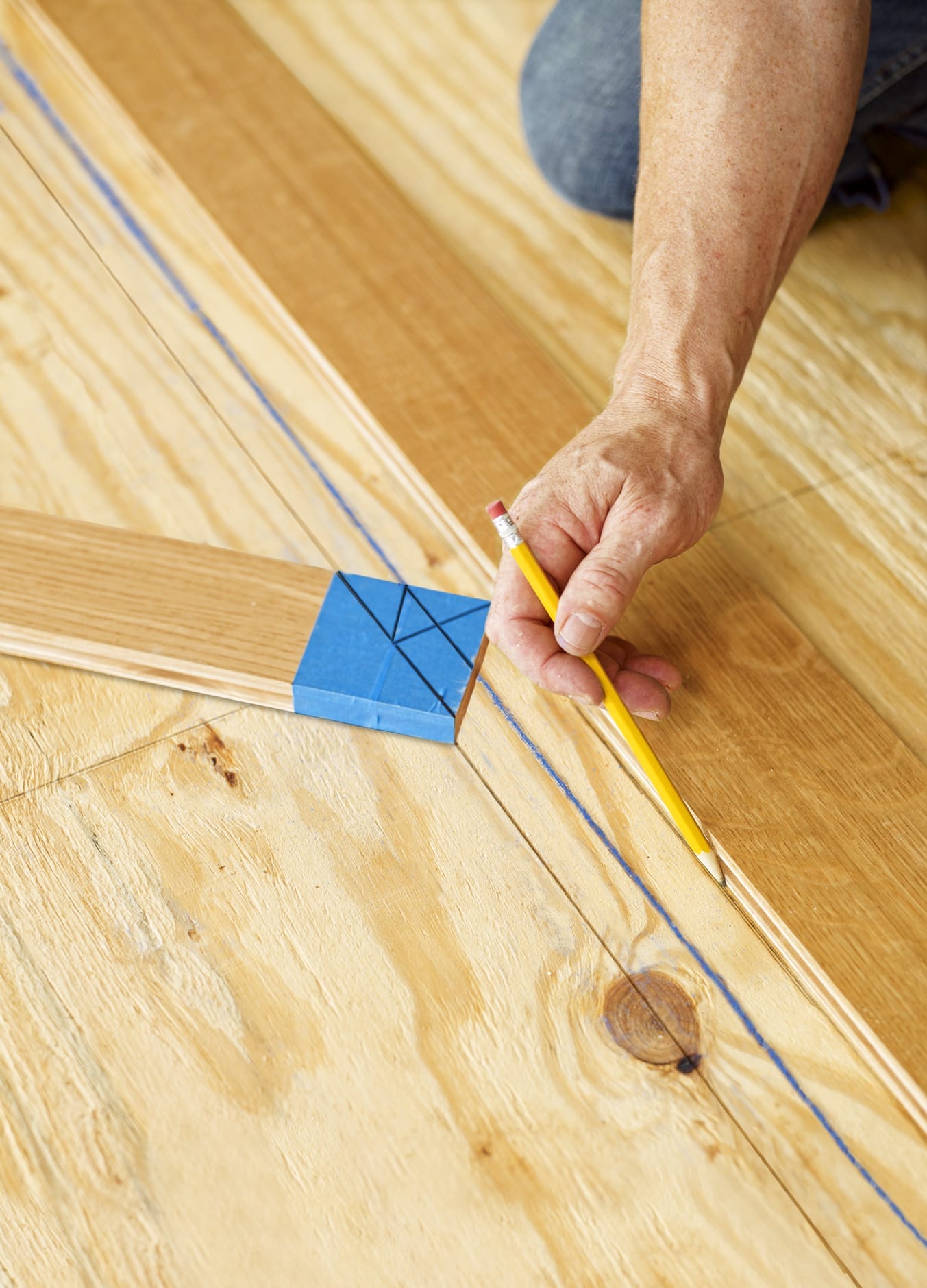 A person places the slat so that the last line they drew is over the centerline and  makes marks with a pencil..