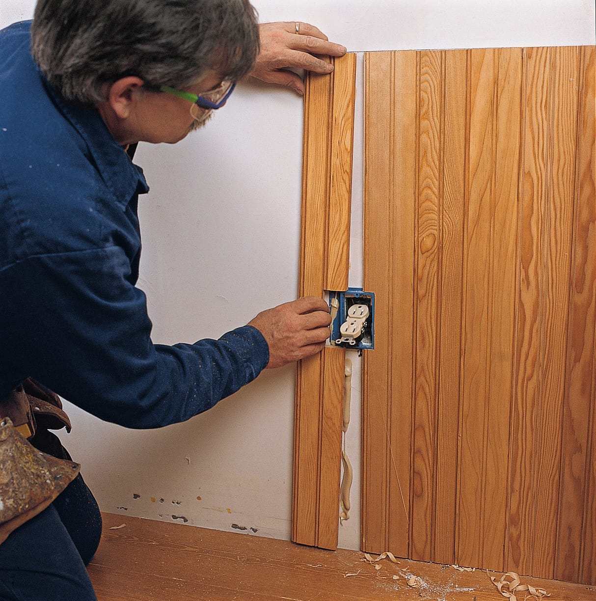 Image of a step of the beadboard wainscoting installation process, which involves cutting the beadboard around electrical outlets