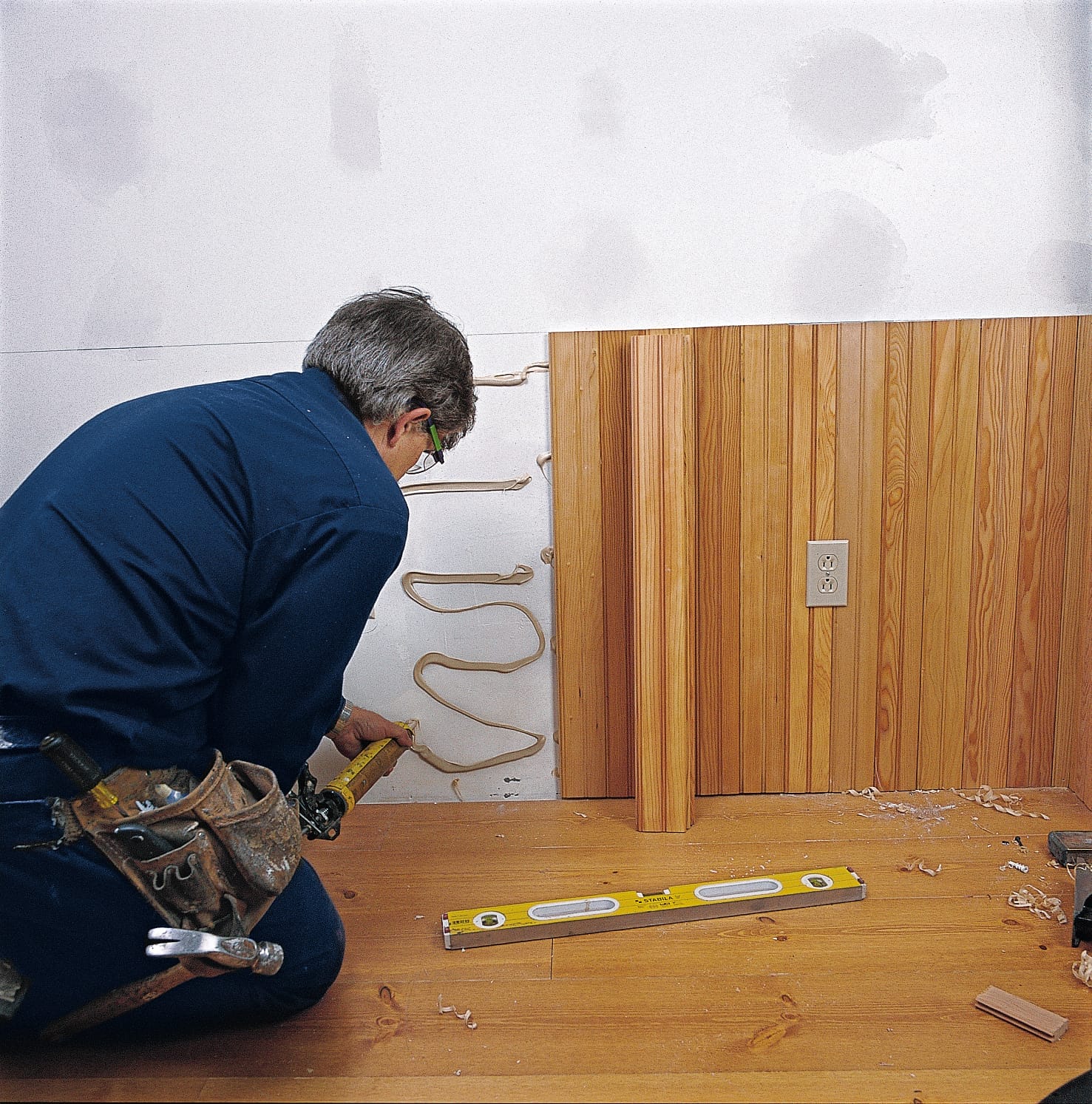 Image of a step of the beadboard wainscoting installation process, which involves gluing and nailing the beadboard panels