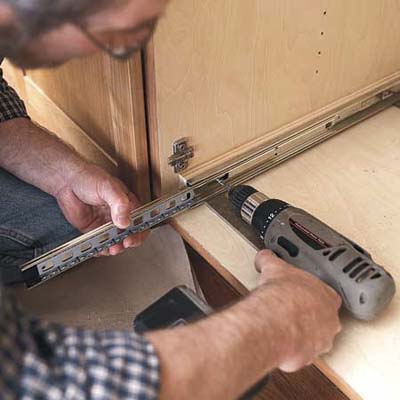 drilling in the slides of the pull-out kitchen shelf into the cabinet