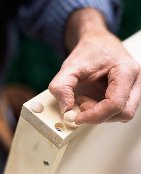using wood buttons to conceal the screw heads of the kitchen shelf