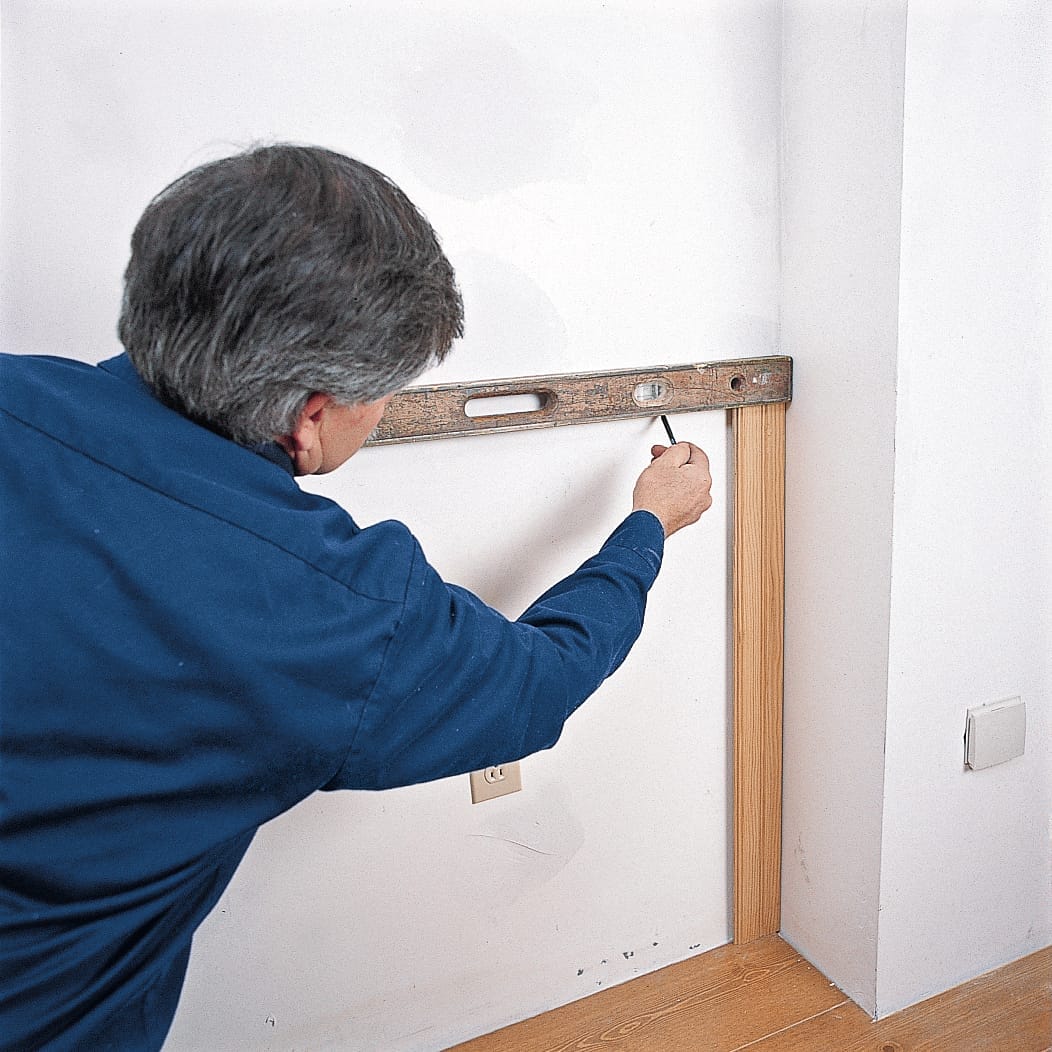 Image of a step of the beadboard wainscoting installation process, which involves drawing the layout line for the beadboard