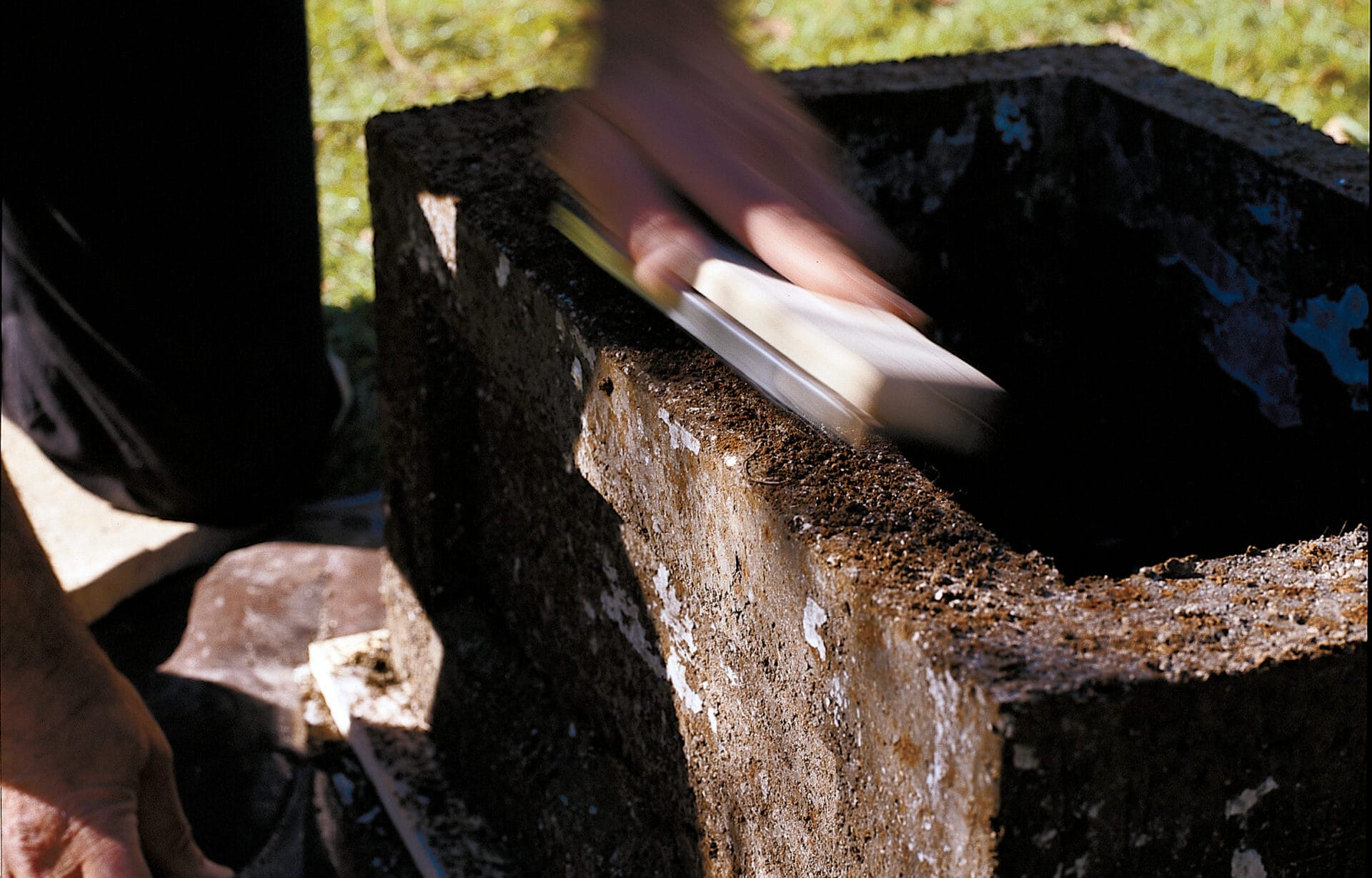 A person sands the cured hypertufa trough.