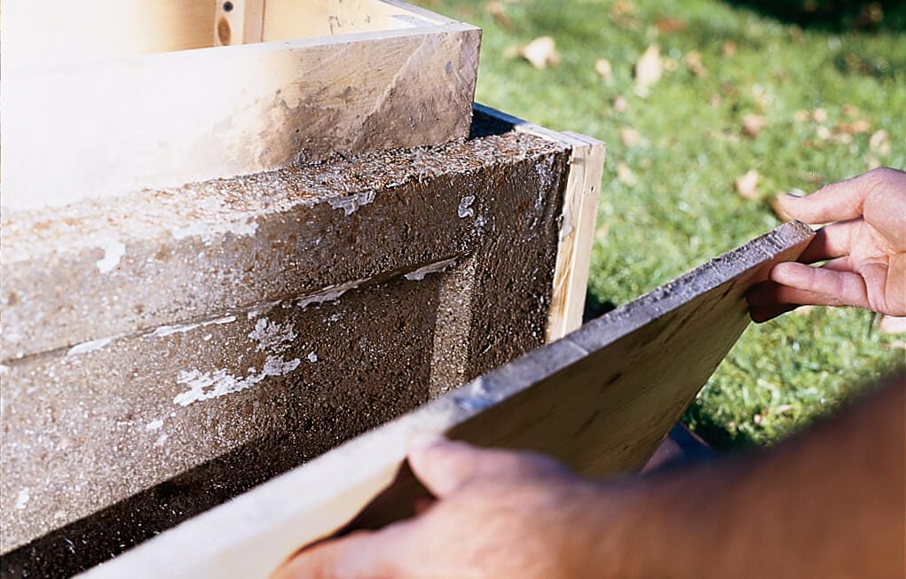 A person removes the mold from the cured hypertufa.