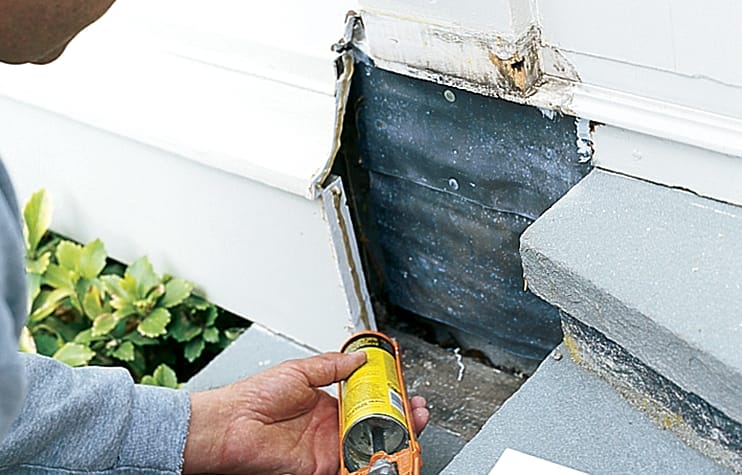 A man applies adhesive to trim edges.