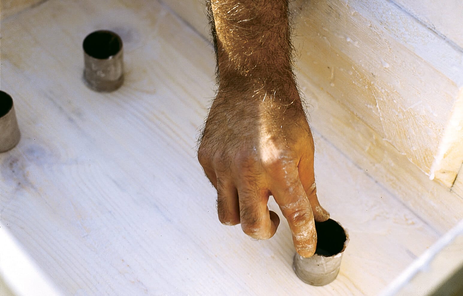 A person adds drainage to a hypertufa trough.