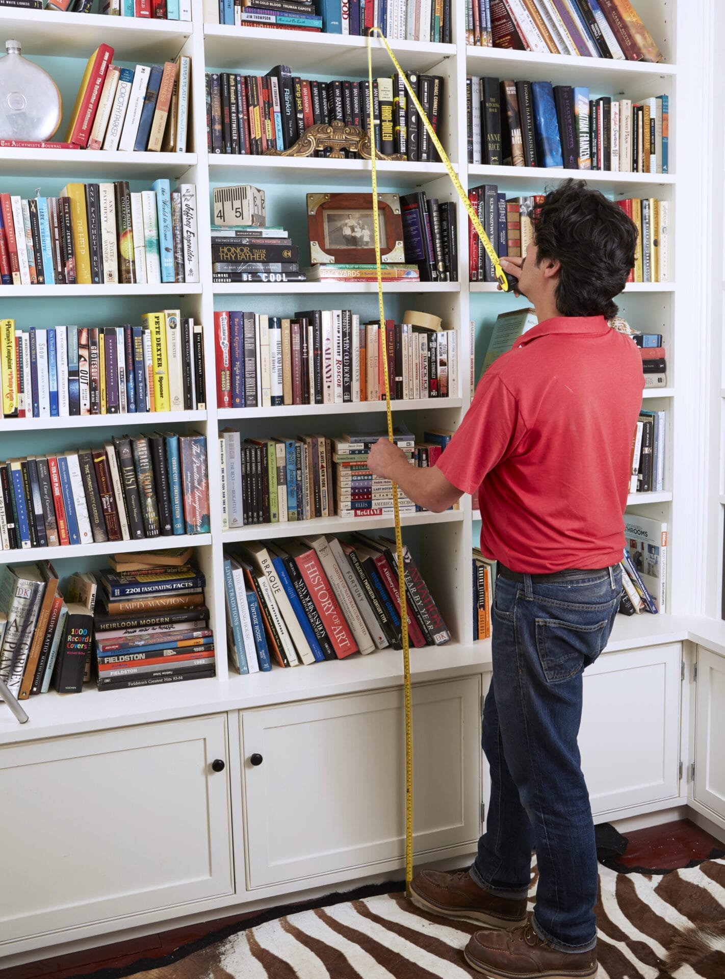 Image of a person completing a step in the DIY rolling library ladder project, which involves cutting the handrails for the ladder. 