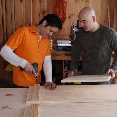 Men installing cleats to assemble the hutch