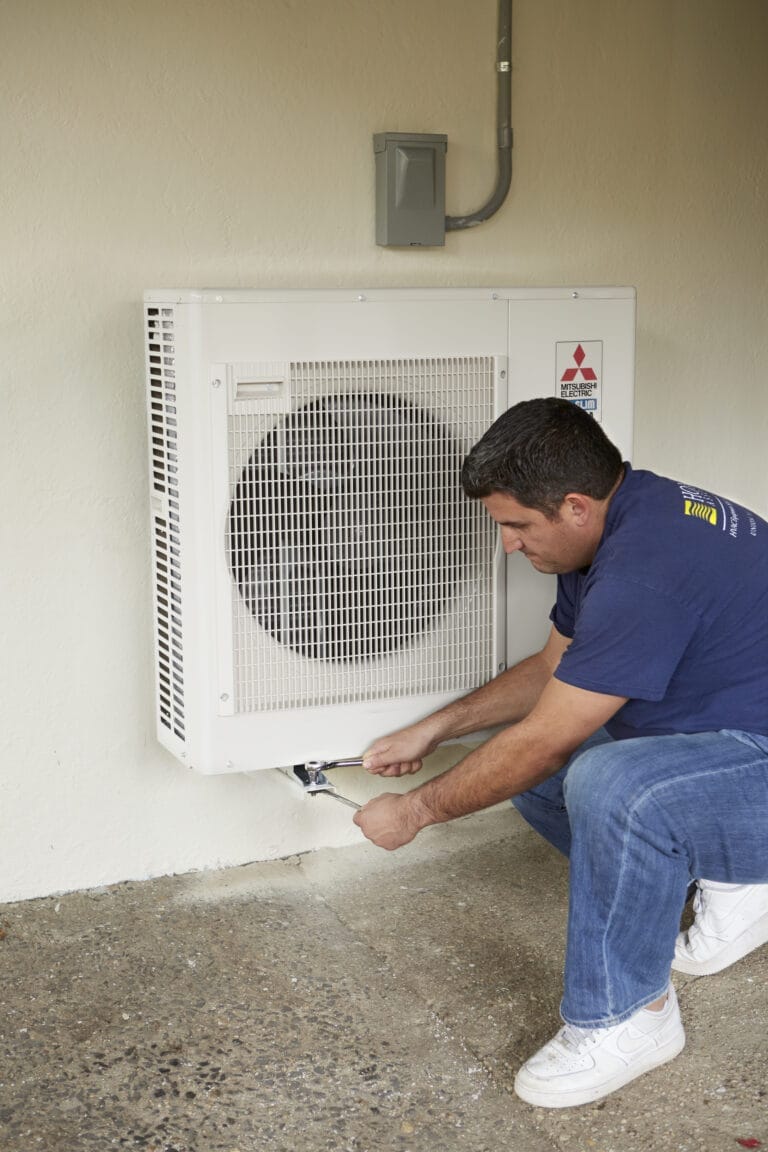 A man checking the airflow from an indoor AC Unit.