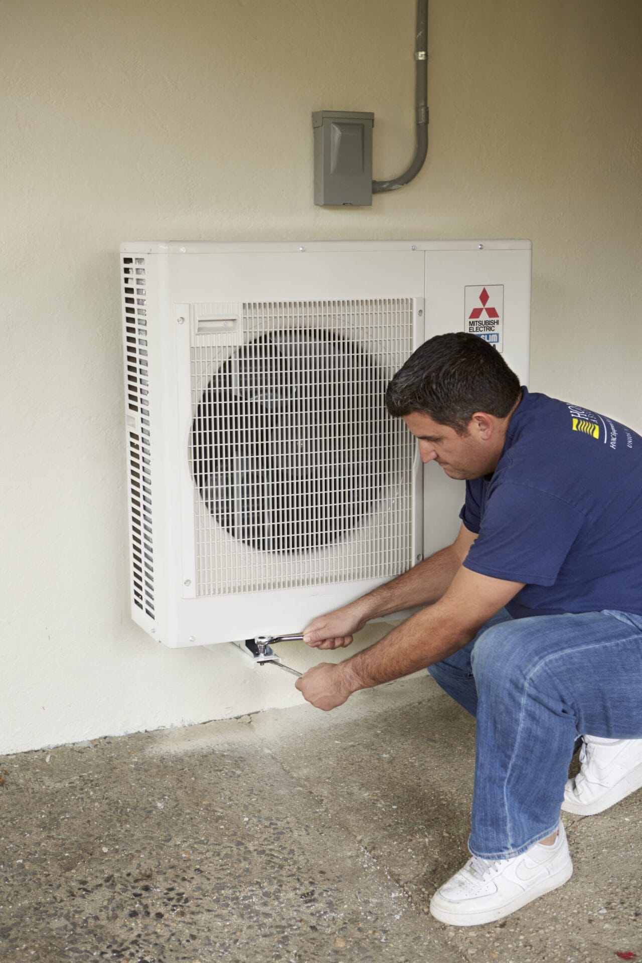 A man checking the airflow from an indoor AC Unit.