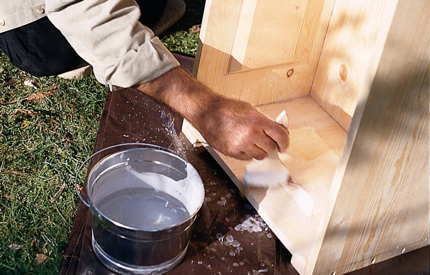 A person applies a release agent to the trough to keep he hypertufa from sticking.