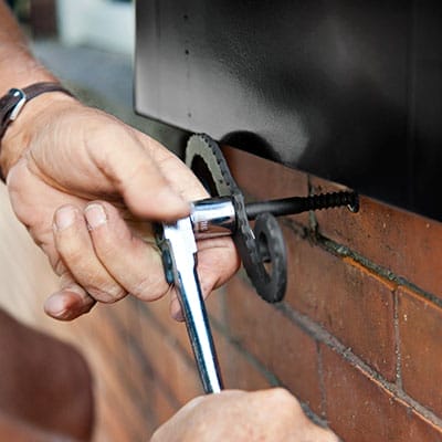 A man attaches the holdback into brick.