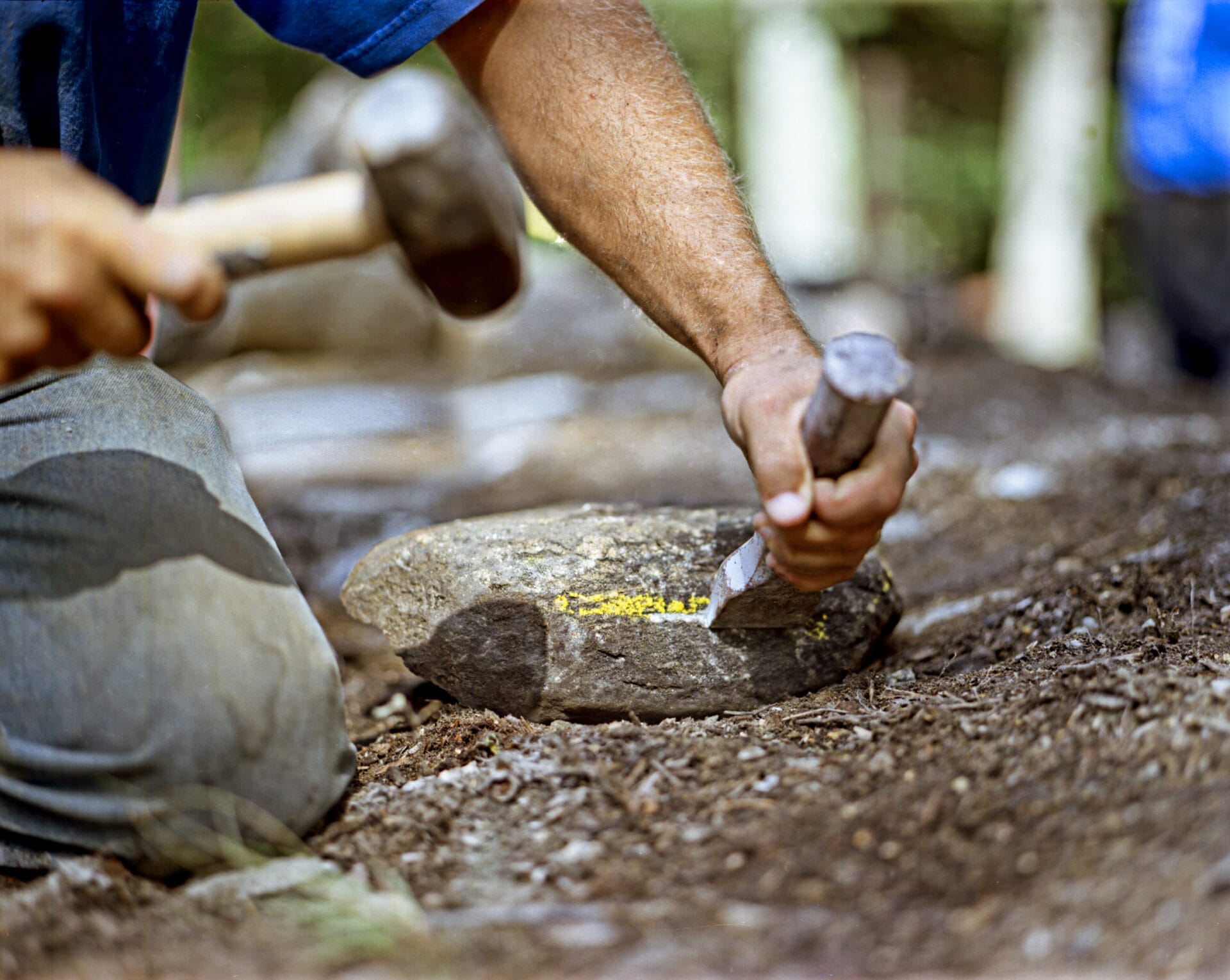 Stone being cut with a hammer and chisel.