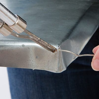 The corners of a zinc tabletop are soldered.