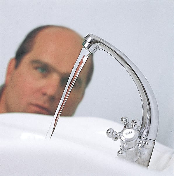 The finishing touches of a pedestal sink are completed.