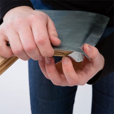 A woman wraps the corners of her zinc tabletop.