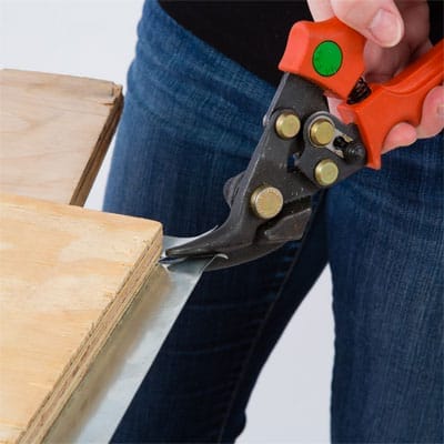 A woman cuts the corners of her tabletop.