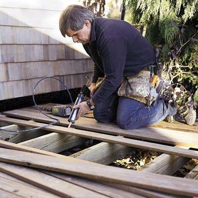 A man attaching trim to a deck.