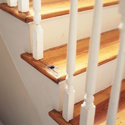 A staircase with a missing baluster in it's center.