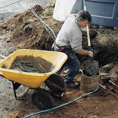A man setting the piers for a deck.