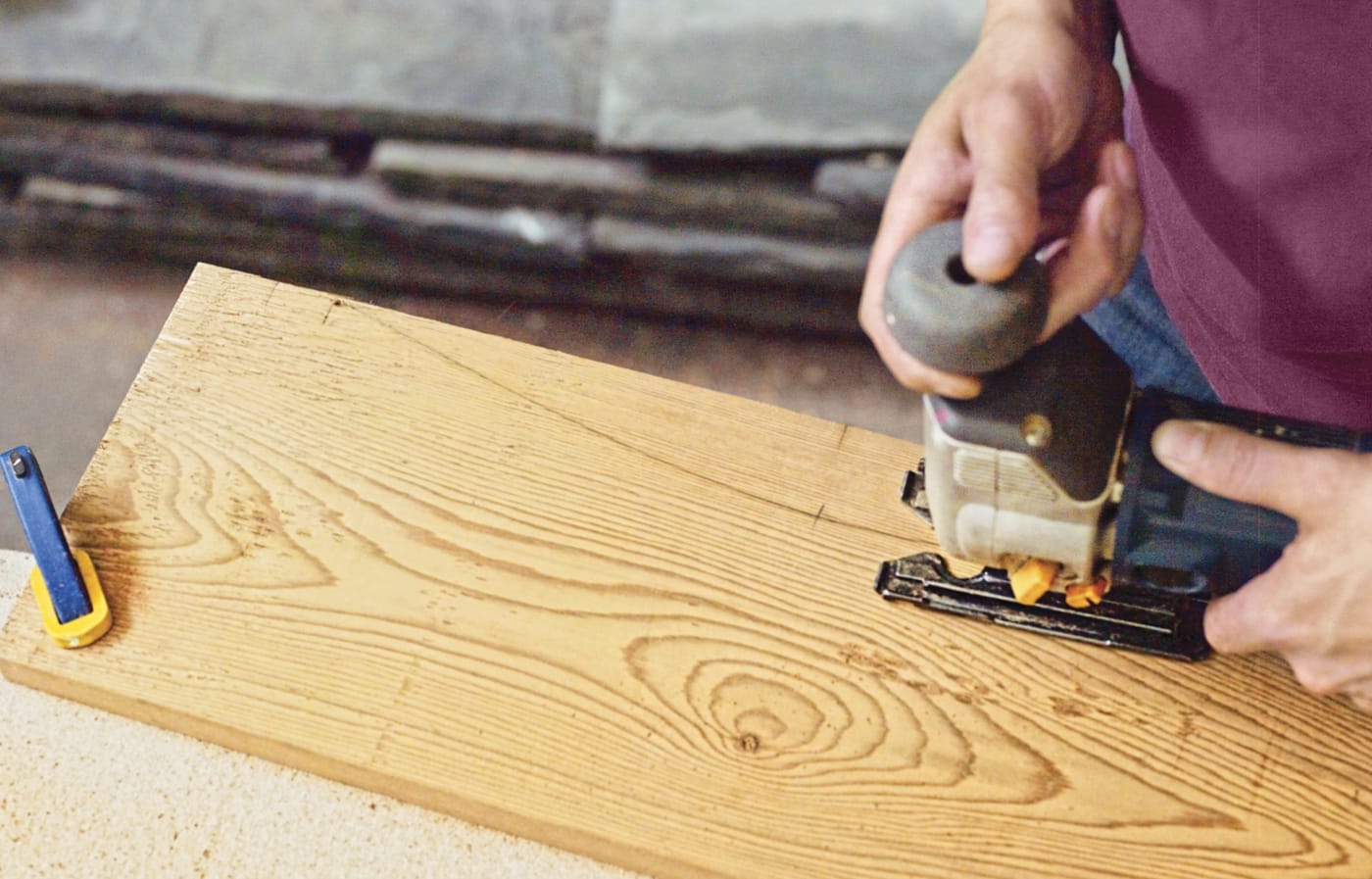 Photo of a person cutting the arm curve of a chair for a Westport chair building project. 