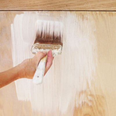 A pickled finish is applied to a wood bench.