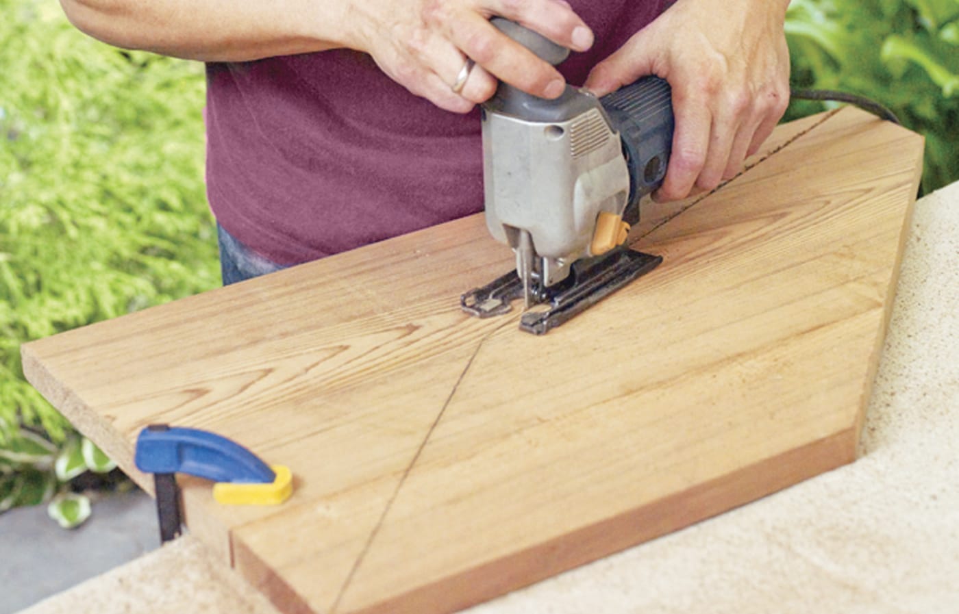 Photo of a person cutting wood to form the back legs for a Westport chair building project. 