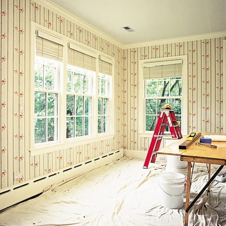 A room that has just had new wallpaper put up, a ladder sits in the corner.