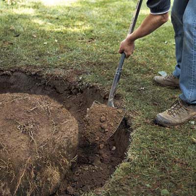 Backfilling the hole with excavated soil.