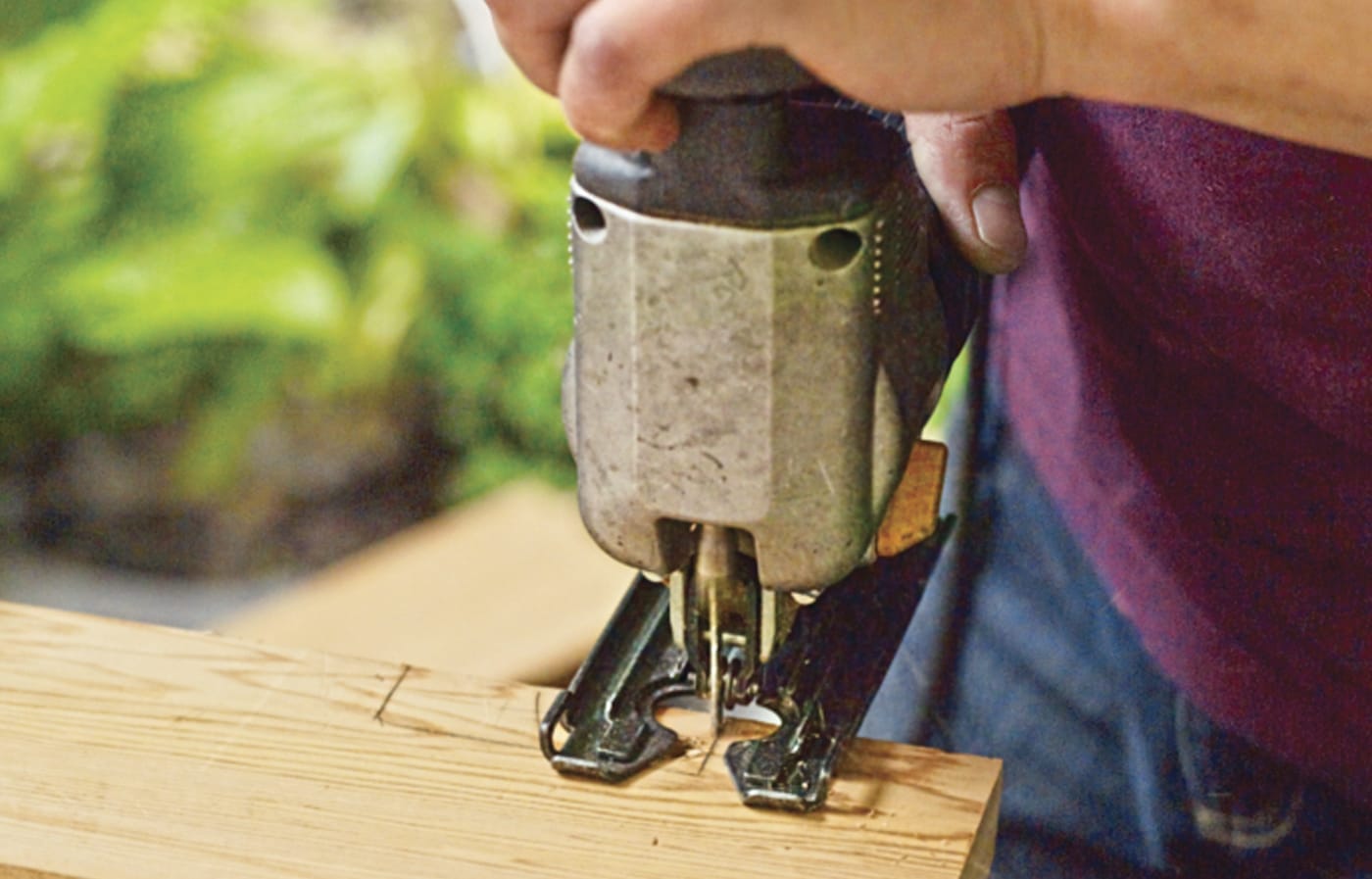 Photo of a person cutting notches out of wood for a Westport chair building project. 